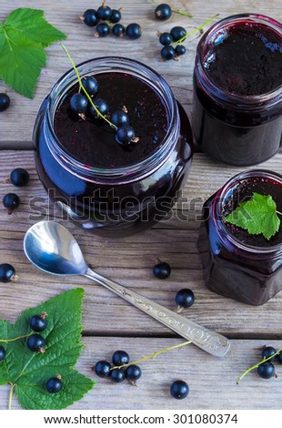 Black currant jam on a wooden background, view from above
