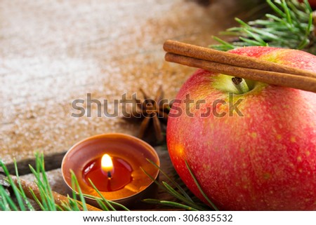 Christmas composition: apple candle and cinnamon stick. Selective focus, copy space background