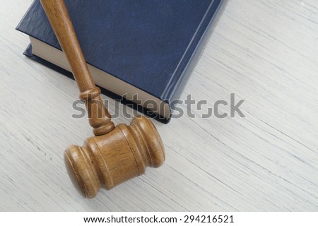 Wooden gavel on red legal book