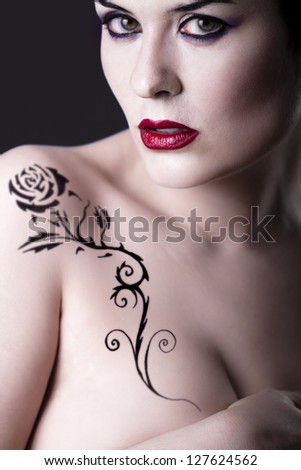Sensual beautiful nude brunette girl with tribal tattoo rose
