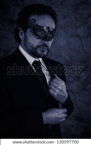 Vampire masked mystery man and elegant black suit over vintage background