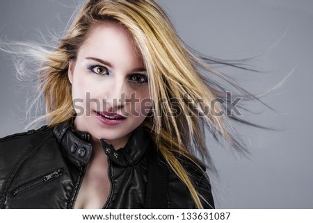 Beautiful young blonde dressed in rocker with hair in the wind