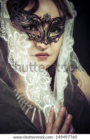 Fantasy virgin, Woman in veil and black dress with venetian mask, queen