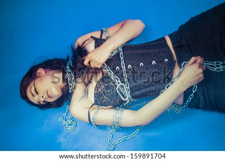 Chains, Fashion shoot of young brunette woman in fetish dress