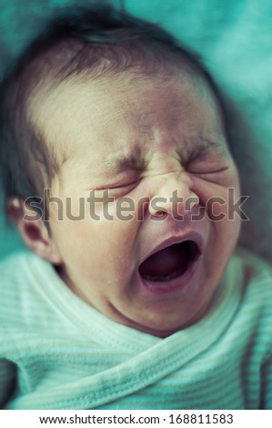 Newborn peacefully sleeping, picture of a baby curled up sleeping on a blanket