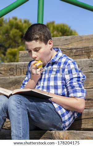 Lifestyle.Young boy reading a book in wooden stairs, summer