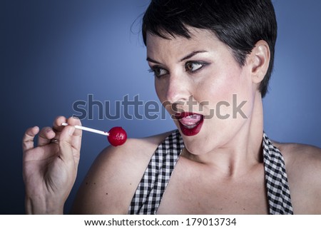 Diet, happy young woman with lollypop  in her mouth on blue background