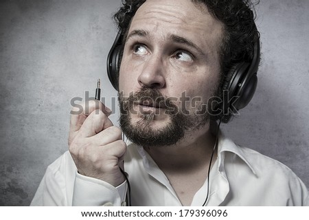 Jack, listening and enjoying music with headphones, man in white shirt with funny expressions