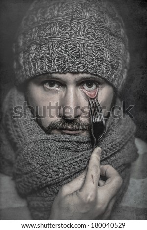 man with a fork in his eye, concept danger, risk