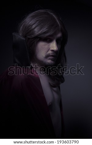 man with long hair and black coat