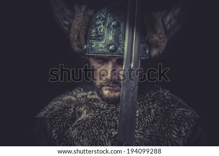 Warning, Viking warrior with a huge sword and helmet with horns