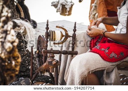 distaff, woman spinning yarn on an old spinning wheel