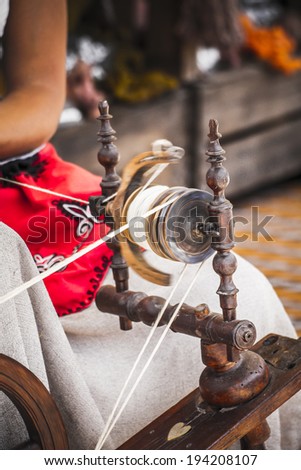 distaff, woman spinning yarn on an old spinning wheel