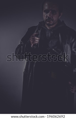 Killer, portrait of stylish man with long leather jacket, gun armed