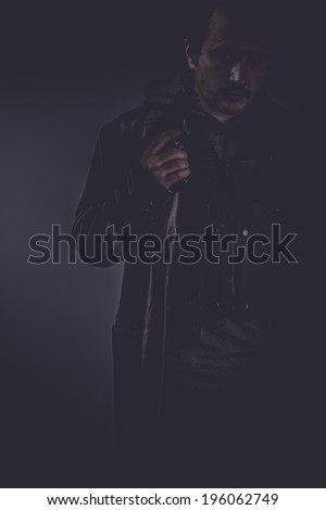 Bodyguard, portrait of stylish man with long leather jacket, gun armed