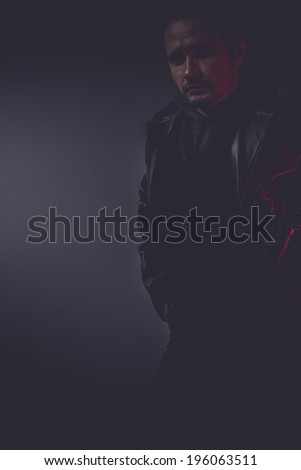 pistol portrait of stylish man with long leather jacket, gun armed
