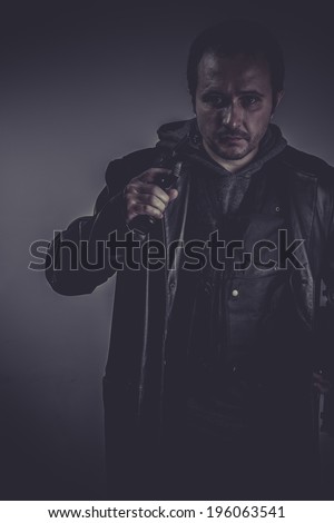 retro portrait of stylish man with long leather jacket, gun armed