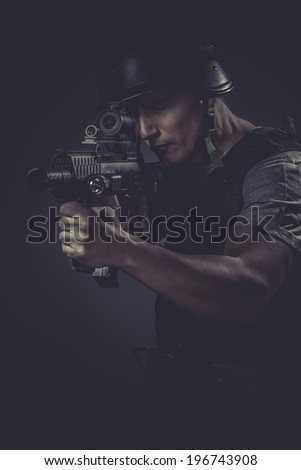 recreation player wearing protective helmet aiming pistol ,black armor and machine gun