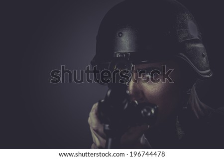 Police, paintball sport player wearing protective helmet aiming pistol ,black armor and machine gun