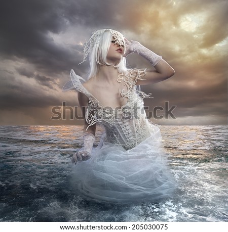 the forces of nature, blonde woman on the rocks with the sea raging and powerful