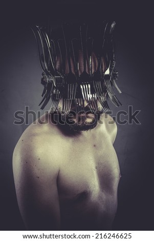 Man with helmet made of forks and knives, concept