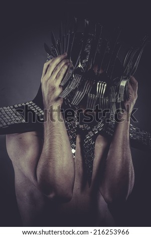eating Man with helmet made of forks and knives, concept