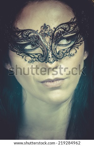 close-up portrait of beautiful brunette woman with carnival venetian mask