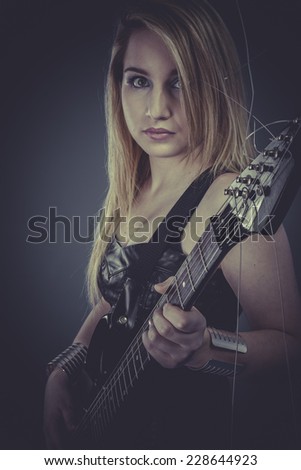 Heavy style, Beautiful blonde with black electric guitar