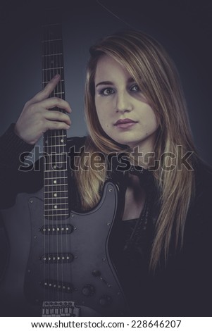 Pretty and beautiful blonde with black electric guitar