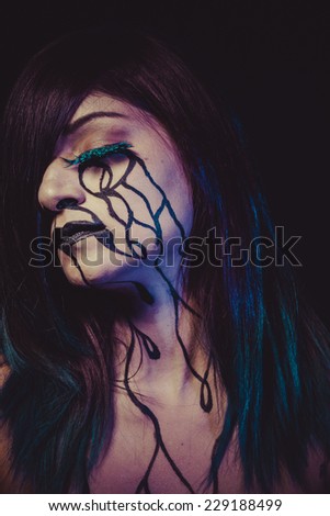 sorrow concept, crying woman with tears and makeup dark light