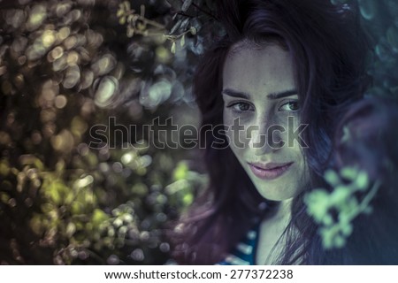 Outdoor, melancholy young girl in a forest with sad gesture