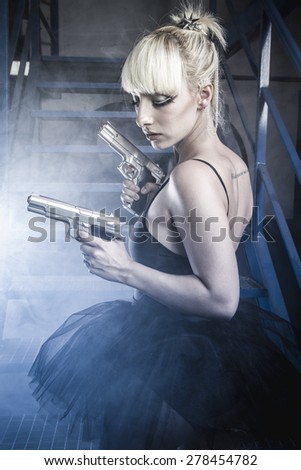 Armed blonde with pistols and dressed in costume ballet dancer