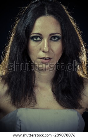 sad brunette woman with long hair and evening gown