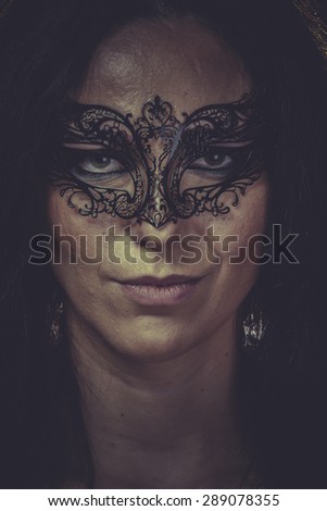 Theater, brunette woman in black mask metal frills