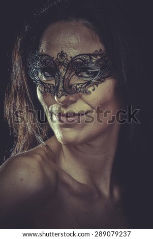 Pretty brunette woman in black mask metal frills