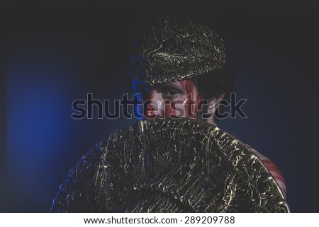 Medieval, bearded man warrior with metal helmet and shield, wild Viking