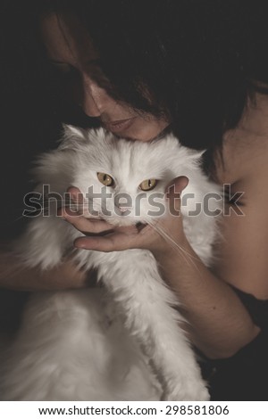 Cute, brunette woman with white Persian cat with long hair