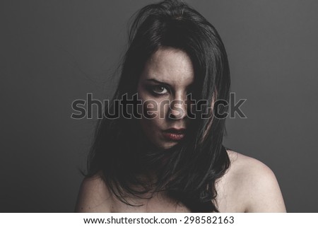 gothic dark woman with large black cloth on gray background, Sadness