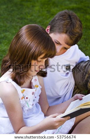 Portrait of cute kids reading books  in natural environment