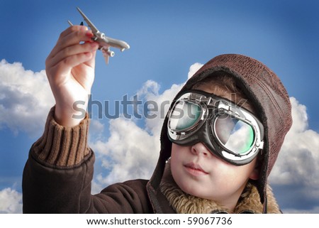 Boy dressed up in pilot?s outfit, jacket, hat and glasses.