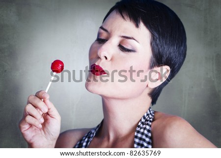 Portrait of lovely brunette with lolly pop, over rusty background