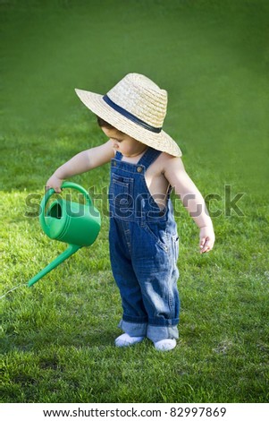 little baby gardener lost in the moment with the sun shinning in his face while he works hard