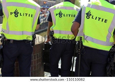 Shot of the back of police officer\'s jacket with the word politie written across the back on Queensday in Amsterdam