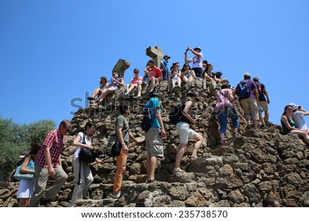 BARCELONA, SPAIN - JUNE 20, 2014: Many People on their way to the Top of the three Crosses (El Calvario) at Gaudi\'s Park Guell in Barcelona.