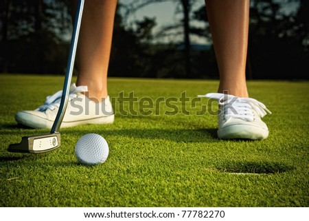 golf girl putting at green