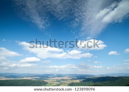 White fluffy clouds in the blue sky seen from the hill top