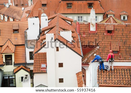 Red roofs of Prague seen from Hradcany. Stare Mesto. Workers on top of the roof repairing slates.