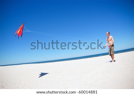 Man with a kite on a beach. Baltic sea.