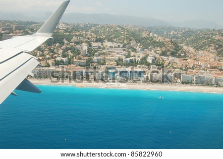 Plane landing over french riviera. Mediterranean sea coast seen behind the window.