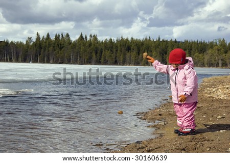 Girl throwing stones in the lake